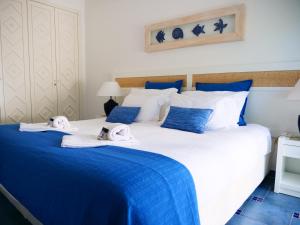 um quarto com uma cama grande e toalhas em Blue Apartment in Prainha em Alvor