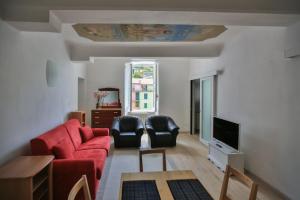 a living room with a red couch and a tv at Residenza Sant’ Antonio in Riomaggiore +7 photos
