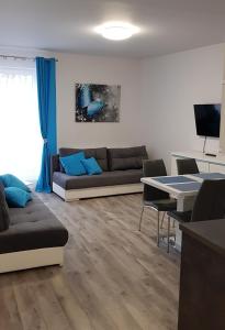 ein Wohnzimmer mit einem Sofa und einem Tisch in der Unterkunft Apartament Wałowa Wejherowo in Wejherowo