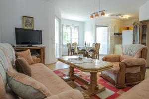 a living room with a table and chairs and a tv at SENITA's Rooms & Apartments in Nin