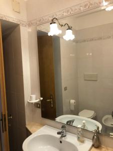 ein Bad mit einem Waschbecken und einem Spiegel in der Unterkunft Dimora del '500 -City Apartment San Vito in San Vito dei Normanni