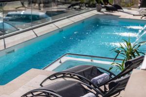 a swimming pool with chairs in front of it at Villa Valis in Baška