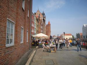 um grupo de pessoas andando por uma rua com um mercado em Apartament Chlebnicka em Gdańsk