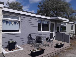 a house with a deck with a table and chairs at Chalet Driftwood in Sandown
