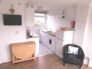 a small kitchen with a sink and a refrigerator at Chalet Driftwood in Sandown