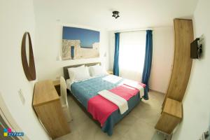 a small bedroom with a bed and a window at Evaggelia Design Suite in Nea Peramos