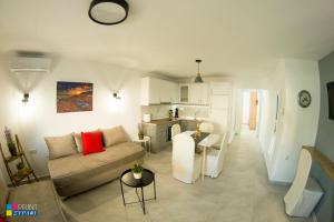 a living room with a couch and a table at Evaggelia Design Suite in Nea Peramos
