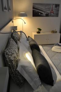 un letto con cuscini bianchi e neri sopra di Il profumo dei Sassi Holiday Home a Matera