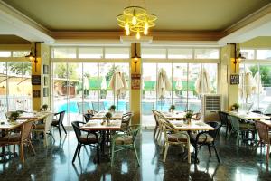 a restaurant with tables and chairs and a swimming pool at Blue Palace Apart Hotel in Marmaris
