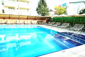 a large swimming pool with chairs and an umbrella at Blue Palace Apart Hotel in Marmaris