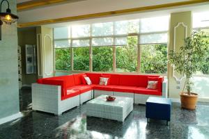 a living room with a red couch in front of a window at Blue Palace Apart Hotel in Marmaris