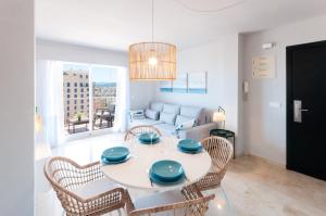 a dining room with a table and chairs and a couch at Calmo Singular Apartments in Gandía