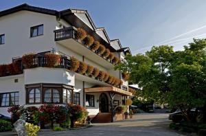 a large white building with flowers and plants on it at Hotel Riegeler Hof in Riegel am Kaiserstuhl