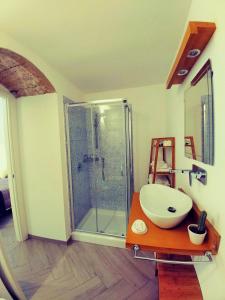 y baño con lavabo y ducha acristalada. en Le Nuvole di Ortigia en Siracusa