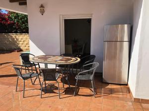 a table and chairs and a refrigerator in a room at Casa de la Colina in Torre del Mar