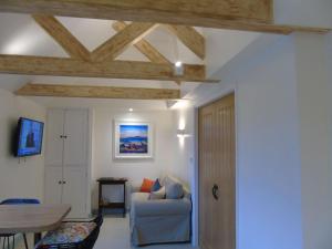 ein Wohnzimmer mit einem Sofa und einem Tisch in der Unterkunft Bond's Cottage Barn in Royal Tunbridge Wells