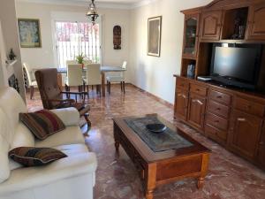 a living room with a couch and a tv and a table at Casa de la Colina in Torre del Mar