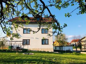 duży biały dom z zielonym dziedzińcem w obiekcie Guest House Klanfar w mieście Grabovac