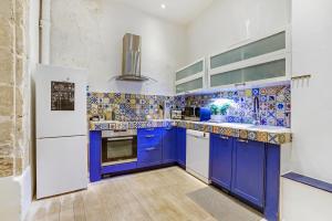 a kitchen with blue cabinets and a white refrigerator at LUXURY LOFT CENTER OF PARIS in Paris