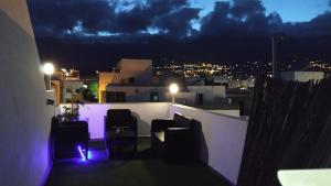 balcón con sillas y vistas a la ciudad por la noche en La Casita Nueva, en El Socorro