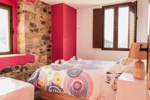 a bedroom with a bed and a stone wall at Villa Palatina in Bolgues