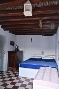 a bedroom with a blue bed and a checkered floor at Stunning town-house in Chora, Serifos in Serifos Chora