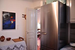 einen Kühlschrank aus Edelstahl in einer Küche mit einem Tisch in der Unterkunft Stunning town-house in Chora, Serifos in Serifos Chora