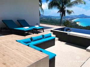 a patio with blue furniture and a view of the water at Villa Ocean Heaven in Chaweng Noi Beach
