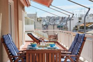 a table and chairs on a balcony with a view at Fabulous 3BD Apt close to Kalimarmaro in Athens