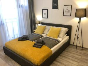 a bedroom with a bed with yellow and gray pillows at Apartament Szczęśliwa 13 - Plac Ratuszowy in Jelenia Góra