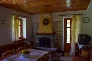 a living room with a table and a fireplace at Holiday Home Dionysis in Chorefto