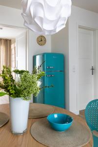 - une table à manger avec un réfrigérateur bleu dans l'établissement SEASIDE APARTMENTS - BEACHHOUSE WAVE, à Eckernförde
