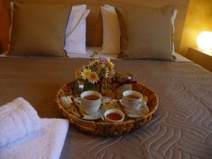 a tray with cups of tea and flowers on a bed at Comfy Apartment in Platanes
