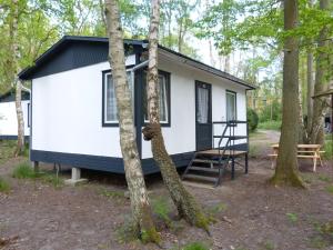 a white tiny house in the woods at DDR Bungalow direkt am Strand auf Rügen in Dranske