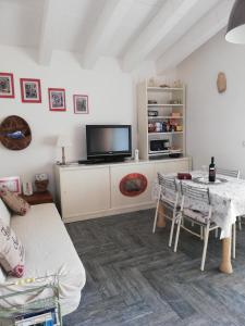 sala de estar con mesa y TV en Appartamento Luelen en Alghero