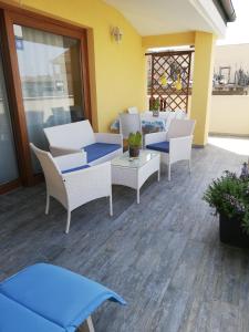 un patio con sillas, mesas y una mesa. en Appartamento Luelen en Alghero