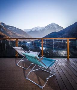 a chair on a deck with a view of mountains at The Vaujany Mountain Lodge in Vaujany