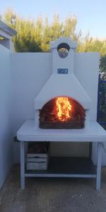 a pizza oven with a fire inside of it at Villa Sunshine in Triscina