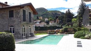 a villa with a swimming pool in front of a house at BELLAGIO DREAMS APT, pool, with private garden, near lake in Bellagio