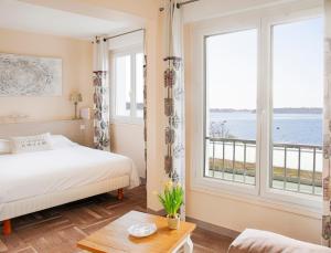 ein Schlafzimmer mit einem Bett und einem großen Fenster in der Unterkunft Hotêl & Spa Du Parc Fétan in Larmor-Baden