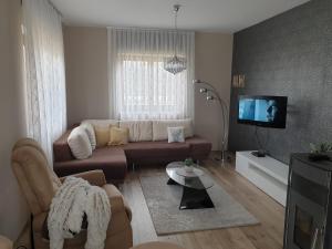 a living room with a couch and a tv at Donna Plitvice Lakes in Grabovac
