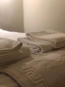 a pile of towels sitting on top of a bed at El Mundo Apartments in Lviv