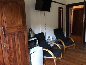 a room with chairs and a microwave and a table at Queenspark Lodge in Bloemfontein