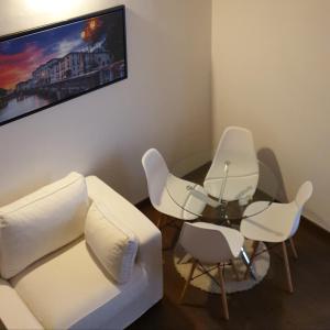 a living room with white chairs and a glass table at La petite maison in Treviso +55 photos
