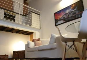 a living room with a white couch and a flat screen tv at La petite maison in Treviso