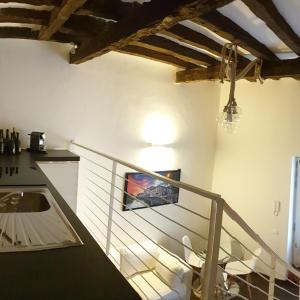 La petite maison في تريفيزو: غرفة بها درج مع طاولة وكراسي