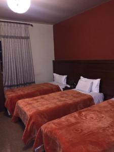 a hotel room with two beds and a window at Kanaan Group Hotel in Baalbeck