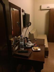 un escritorio con una botella de agua y un plato de comida en Kanaan Group Hotel en Baalbeck
