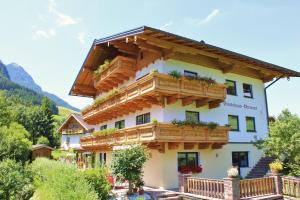 un edificio con balcones de madera y flores. en Gästehaus Oberauer, en Annaberg im Lammertal