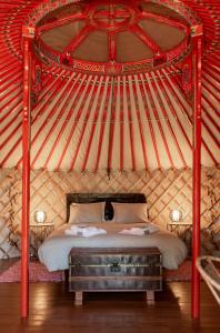 a bedroom with a bed in a yurt at Quinta do Ragal in Lavacolhos
